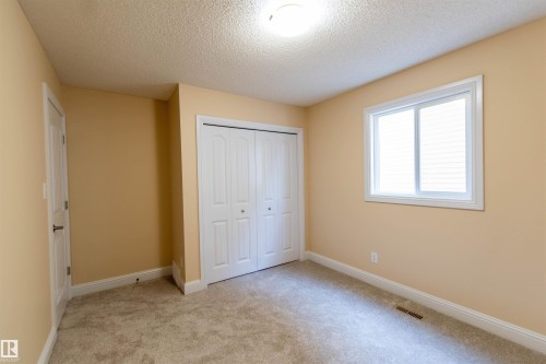 Wall-to-wall carpeting, bi-fold closet doors, white window trim, and a flush mount ceiling light fixture - 1419 Chahley Place Nw, Edmonton, AB - Indoor Photo Showing Other Room
