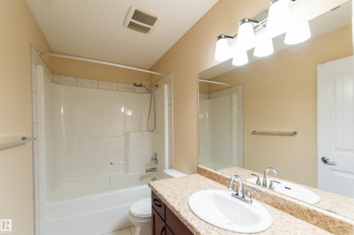 Vanity with a polished chrome faucet, under-mount sink, and granite-finish countertop - 1419 Chahley Place Nw, Edmonton, AB - Indoor Photo Showing Bathroom
