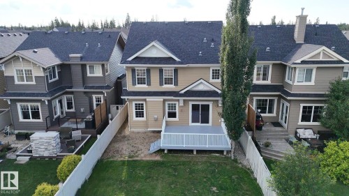 Two-story residence with a light beige siding, a dark shingle roof, and white window trim - 1419 Chahley Place Nw, Edmonton, AB - Outdoor With Facade