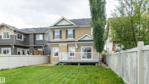 Two-story exterior with light beige siding, dark-shingled roof, and white-trimmed windows - 1419 Chahley Place Nw, Edmonton, AB - Outdoor With Deck Patio Veranda