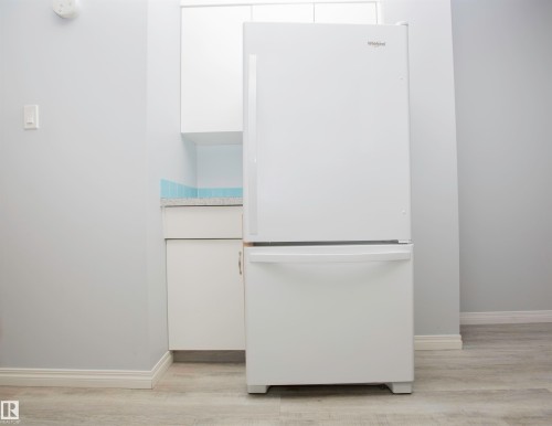 White bottom-freezer refrigerator paired with white cabinetry - 11131 52 Street Nw, Edmonton, AB - Indoor