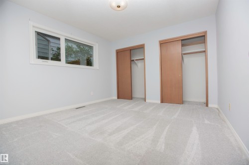 Spacious room featuring light grey carpeting, white baseboards, and light grey painted walls - 11131 52 Street Nw, Edmonton, AB - Indoor Photo Showing Other Room