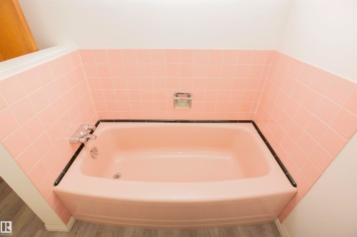 Built-in bathtub featuring pink tile surround and integrated chrome fixtures - 11131 52 Street Nw, Edmonton, AB - Indoor Photo Showing Bathroom