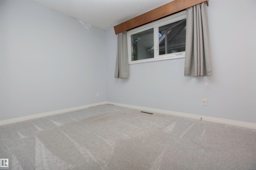 Light gray wall paint with white baseboards and gray patterned carpeting - 11131 52 Street Nw, Edmonton, AB - Indoor Photo Showing Other Room