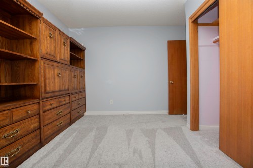 Built-in wood cabinetry and shelving provide extensive storage - 11131 52 Street Nw, Edmonton, AB - Indoor Photo Showing Other Room