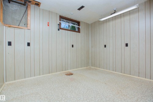 Vertical wood-look paneling walls with light-toned linoleum flooring - 11131 52 Street Nw, Edmonton, AB - Indoor Photo Showing Other Room