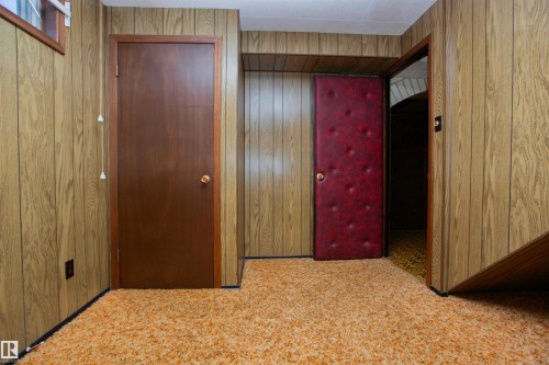Interior space featuring paneled walls, textured carpeting, and multiple doorways - 11131 52 Street Nw, Edmonton, AB - Indoor