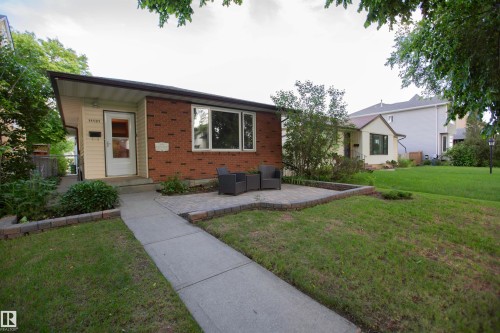 Brick and siding exterior with a pitched roofline, featuring a front patio with paver stones and a concrete walkway - 11131 52 Street Nw, Edmonton, AB - Outdoor