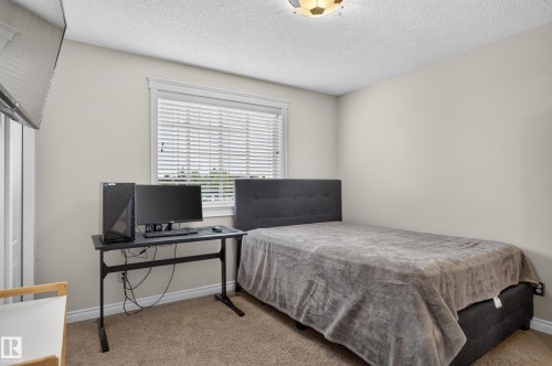 Neutral wall paint, textured ceiling, carpeted flooring, window with blinds, and white trim throughout - 12724 148 Avenue Nw, Edmonton, AB - Indoor Photo Showing Bedroom