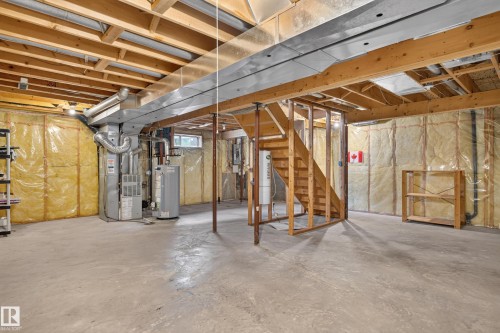 Unfinished basement featuring exposed wood joists, concrete flooring, insulated walls, and visible utility systems - 12724 148 Avenue Nw, Edmonton, AB - Indoor Photo Showing Basement