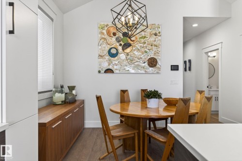 Vaulted ceiling, geometric chandelier, wood-finish flooring, built-in wood-finish cabinetry, and recessed lighting - 45 Evermore Crescent, St. Albert, AB - Indoor Photo Showing Dining Room