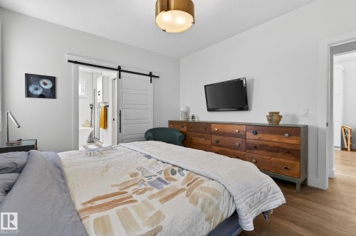 Recessed lighting, wood-finish flooring, and a barn door entry to a bathroom - 45 Evermore Crescent, St. Albert, AB - Indoor Photo Showing Bedroom