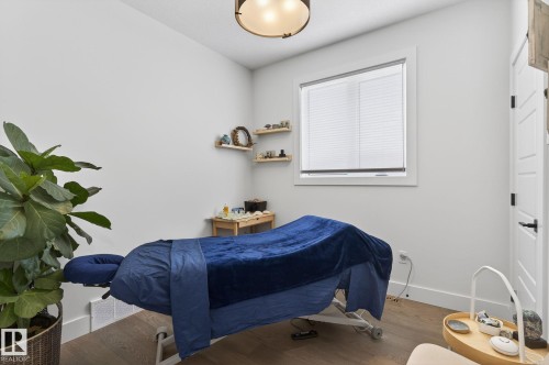Hardwood-finish flooring, white walls, built-in window with blinds, and a paneled interior door with black hardware - 45 Evermore Crescent, St. Albert, AB - Indoor Photo Showing Bedroom