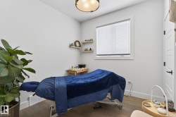 Hardwood-finish flooring, white walls, built-in window with blinds, and a paneled interior door with black hardware - 