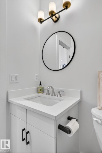 White vanity with matte black hardware, integrated rectangular sink, and light-toned countertop - 45 Evermore Crescent, St. Albert, AB - Indoor Photo Showing Bathroom