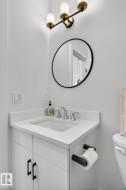 White vanity with matte black hardware, integrated rectangular sink, and light-toned countertop - 
