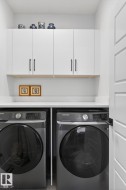 Built-in white cabinetry with black hardware, white countertop, and white interior door - 