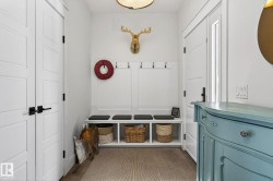 Entryway featuring a built-in bench with cubby storage, shaker-style doors, and wood-finish flooring - 