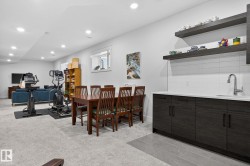Recessed lighting, wood-finish cabinetry, quartz-finish countertop, subway tile backsplash, and floating shelves - 