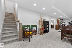 Carpeted staircase with wood handrail, recessed lighting, and wall-to-wall carpeting - 