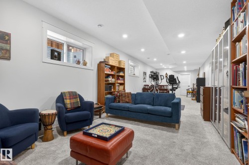 Recessed lighting illuminates a spacious room featuring light gray carpeting and white painted walls - 45 Evermore Crescent, St. Albert, AB - Indoor Photo Showing Living Room