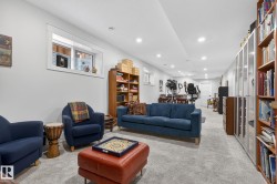 Recessed lighting illuminates a spacious room featuring light gray carpeting and white painted walls - 