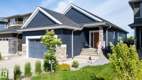 Exterior featuring dark blue siding, white trim, stone accents, and a paved driveway - 45 Evermore Crescent, St. Albert, AB - Outdoor