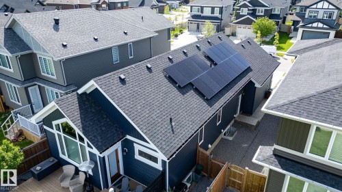 Dark shingle roofing, solar panel array, dark panel siding, multiple white-framed windows, and a wood-finish deck - 45 Evermore Crescent, St. Albert, AB - Outdoor