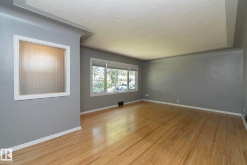 Hardwood flooring, painted walls, white trim, recessed window with blinds, interior window with ribbed glass - 12322 94 Street Nw, Edmonton, AB - Indoor Photo Showing Other Room