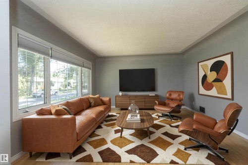 Expansive window array, light wood-finish flooring, crown molding, and a built-in media console - 12322 94 Street Nw, Edmonton, AB - Indoor Photo Showing Living Room