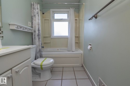 White vanity with cabinet storage, integrated sink, and white ceramic tile flooring - 12322 94 Street Nw, Edmonton, AB - Indoor Photo Showing Bathroom