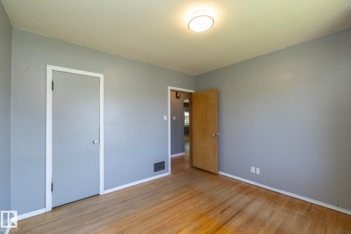 Hardwood flooring, light gray walls, white trim, and a flush mount ceiling light - 12322 94 Street Nw, Edmonton, AB - Indoor Photo Showing Other Room