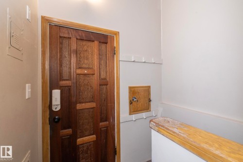 Decorative wood entry door with smart lock system - 12322 94 Street Nw, Edmonton, AB - Indoor Photo Showing Other Room