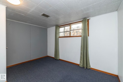 Recessed ceiling with acoustic tiles, wood-finish trim, and wall-mounted lighting - 12322 94 Street Nw, Edmonton, AB - Indoor Photo Showing Other Room