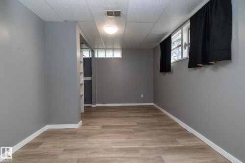 Wood-finish flooring, recessed lighting, drop ceiling, and built-in shelving - 12322 94 Street Nw, Edmonton, AB - Indoor Photo Showing Other Room