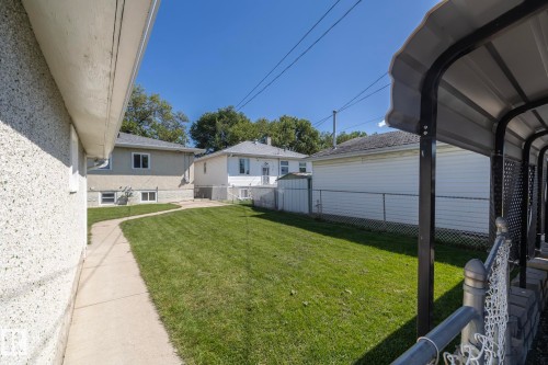 Expansive green lawn with a concrete pathway and chain-link fencing - 12322 94 Street Nw, Edmonton, AB - Outdoor With Exterior