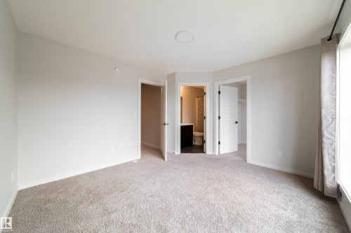 Spacious room with light-colored carpeting, neutral wall paint, and white trim - 7109 Chivers Close Sw, Edmonton, AB - Indoor Photo Showing Other Room