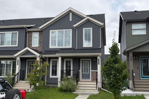 Multi-level property exterior with dark siding and white trim - 7109 Chivers Close Sw, Edmonton, AB - Outdoor With Facade