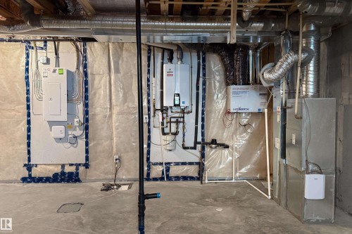 Unfinished basement with concrete flooring and exposed ceiling joists, featuring an electrical panel, water heater, and HVAC system - 7109 Chivers Close Sw, Edmonton, AB - Indoor Photo Showing Basement