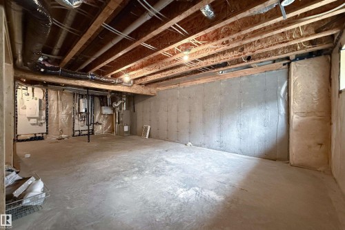 Unfinished basement featuring exposed wood joists, concrete flooring, and visible utility installations - 7109 Chivers Close Sw, Edmonton, AB - Indoor Photo Showing Basement