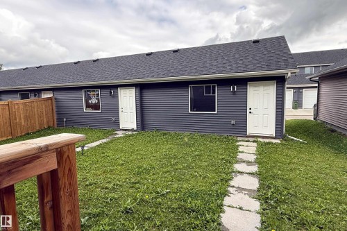 Backyard featuring a stone paver pathway, wood fencing, and a dark shingle roof - 7109 Chivers Close Sw, Edmonton, AB - Outdoor With Exterior
