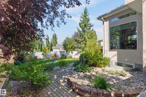 Extensive landscaping featuring a paver stone pathway, mature trees, and a terraced garden bed - 30 Hillcrest Place, St. Albert, AB - Outdoor