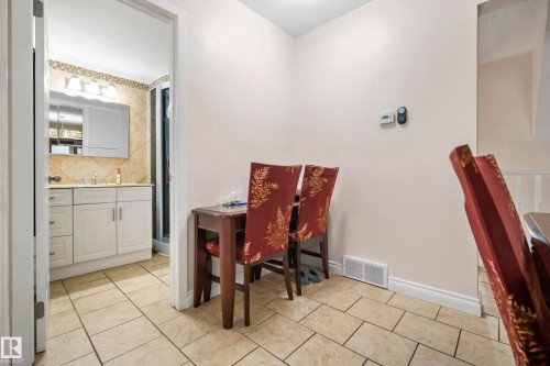 Main Floor Bathroom featuring a single vanity with storage, tiled backsplash, and recessed lighting. Also, area for a desk. - #25 3811 85 St Nw, Edmonton, AB - Indoor