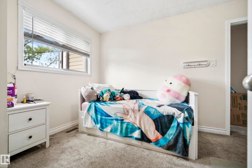 Recessed window with blinds, light-toned walls, and grey carpet flooring - #25 3811 85 St Nw, Edmonton, AB - Indoor Photo Showing Bedroom