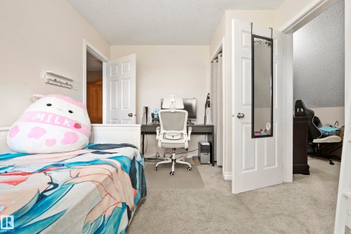 Neutral wall paint, white trim, light-colored carpeting, white paneled doors, and a built-in half wall - #25 3811 85 St Nw, Edmonton, AB - Indoor Photo Showing Bedroom