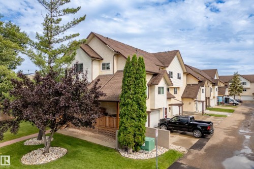 Attached garage parking, multiple pitched roofs, private covered porch, exterior siding, and landscaped grounds - #25 3811 85 St Nw, Edmonton, AB - Outdoor