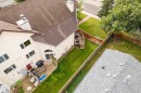 Expansive property featuring a brown shingle roof, light-colored siding, a wooden deck, a patio, and a grass lawn - #25 3811 85 St Nw, Edmonton, AB  - Outdoor 