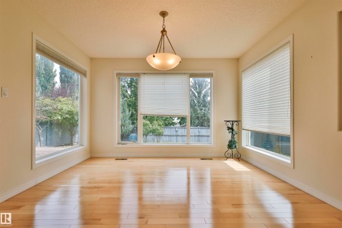 Recessed lighting, wood-finish flooring, multiple large windows, and a ceiling-mounted light fixture - 237 Darlington Crescent Nw, Edmonton, AB - Indoor Photo Showing Other Room