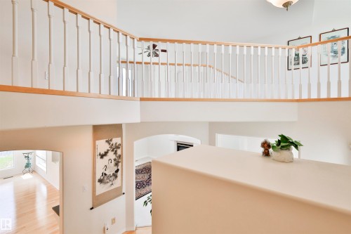 Two-story interior with white baluster railing and wood-finish handrails - 237 Darlington Crescent Nw, Edmonton, AB - Indoor Photo Showing Other Room