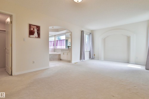 Carpeted flooring, arched architectural detail, recessed alcove, double-pane window, built-in vanity with cabinetry - 237 Darlington Crescent Nw, Edmonton, AB - Indoor Photo Showing Other Room